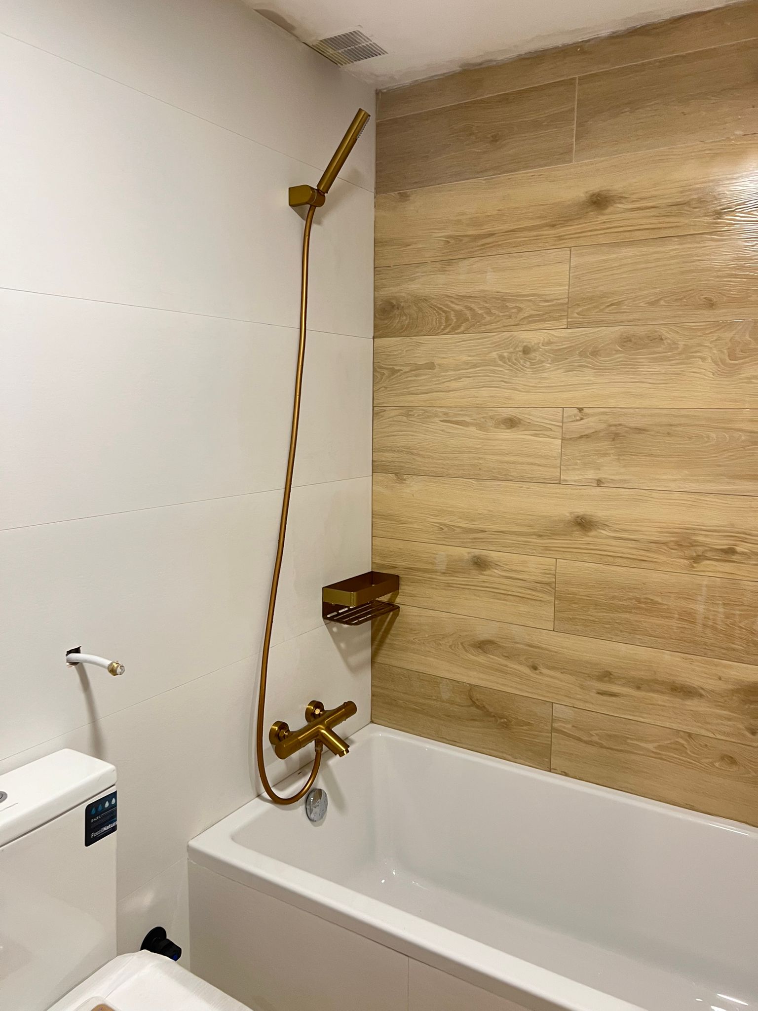 Vista completa del baño con azulejos efecto madera